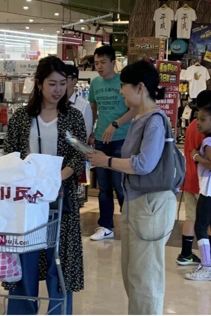 A woman sharing the Gospel and a cookie with a shopper in Japan during the Gospel & Cookies outreach